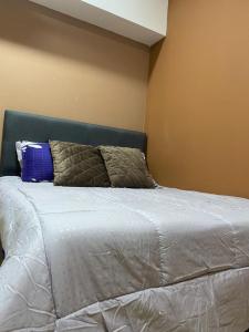 a bed with two pillows on top of it at M Centura Sentul in Kuala Lumpur