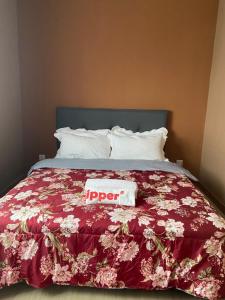 a bed with a red comforter with a nap sign on it at M Centura Sentul in Kuala Lumpur