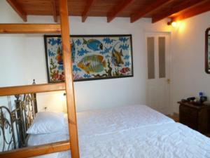 a bedroom with a bunk bed and a painting on the wall at Villa Angela, Panoramablick übers Meer in Vasilikos