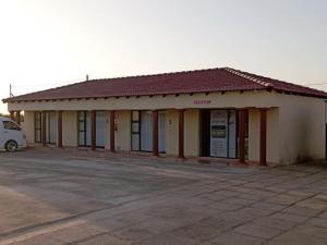 un bâtiment avec une camionnette garée dans un parking dans l'établissement Maboe Leisure Resort, à Rustenburg