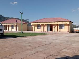 a building with a parking lot in front of it at Maboe Leisure Resort in Rustenburg