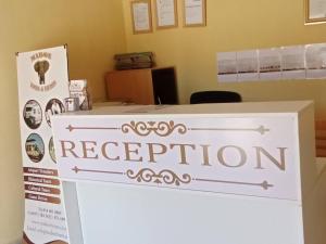a sign for a reception desk in an office at Maboe Leisure Resort in Rustenburg