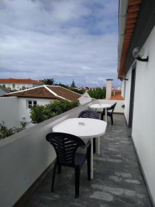 une rangée de tables et de chaises sur un balcon dans l'établissement Bettencourt 2 Rooms, à Santa Cruz da Graciosa