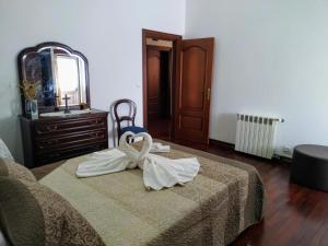 a bedroom with a bed with a dresser and a mirror at Bettencourt 2 Rooms in Santa Cruz da Graciosa