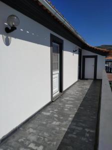 een wit gebouw met een deur en een loopbrug bij Bettencourt 2 Rooms in Santa Cruz da Graciosa