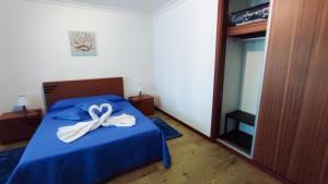 una camera da letto con un letto blu con un arco sopra di Bettencourt House a Santa Cruz da Graciosa