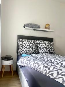 a bedroom with a bed with a black and white comforter at Studioapartment M15 im Plagwitzer Szeneviertel in Leipzig