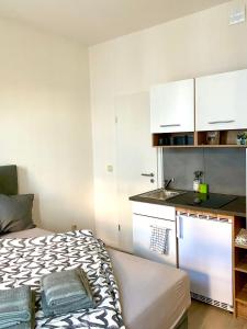 a small room with a bed and a kitchen at Studioapartment M15 im Plagwitzer Szeneviertel in Leipzig