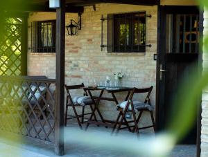 una mesa y sillas en un patio con una pared de ladrillo en La Capparuccia, en Civitanova Marche