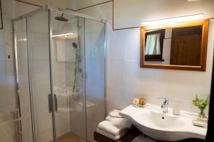 bagno con lavandino e doccia in vetro di La Capparuccia a Civitanova Marche