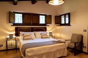 1 dormitorio con 1 cama, 1 silla y ventanas en La Capparuccia, en Civitanova Marche