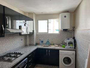 a kitchen with a sink and a washing machine at Appartement jad in Casablanca