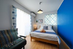 um quarto azul com uma cama e uma janela em 海まで徒歩1分 浜比嘉島まで車で10分 12名宿泊可能な宿泊施設 エムズハウス em Uruma