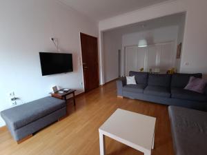 ein Wohnzimmer mit einem Sofa und einem Tisch in der Unterkunft 2 bedroom apartment near syntagma in Athen