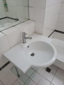 ein weißes Waschbecken in einem weiß gefliesten Bad in der Unterkunft 2 bedroom apartment near syntagma in Athen
