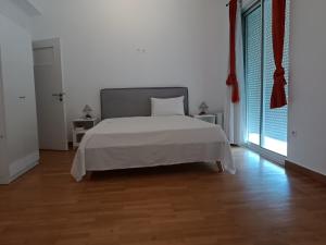 ein weißes Schlafzimmer mit einem Bett und einem großen Fenster in der Unterkunft 2 bedroom apartment near syntagma in Athen
