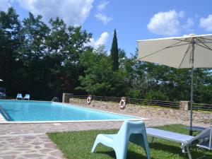 una piscina con sombrilla, mesa y sillas en Pleasant Apartment with Swimming Pool Garden BBQ Parking, en Lucolena in Chianti