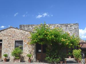 un edificio de piedra con un árbol con naranjas. en Pleasant Apartment with Swimming Pool Garden BBQ Parking, en Lucolena in Chianti