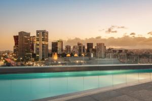 a swimming pool on the roof of a building with a city skyline at Hotel SB Plaza Europa in Hospitalet de Llobregat