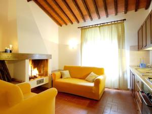 sala de estar con sofá amarillo y chimenea en Pleasant Apartment with Swimming Pool Garden BBQ Parking, en Lucolena in Chianti