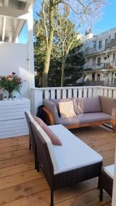een patio met een bank en een tafel op een balkon bij Cozy apparment close to center with big terrace in Amsterdam