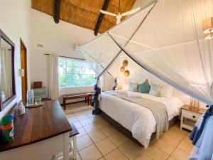 a bedroom with a bed with a mosquito net at Drift Inn in Victoria Falls