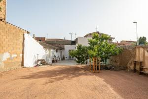 a dirt road with buildings and a tree in a village at Casa Claudia in Assemini