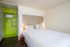 - une chambre avec un grand lit blanc et un placard vert dans l'établissement Campanile Reims Sud - Bezannes, à Reims