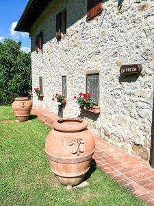 a stone building with three large vases in front of it at Casa Vacanza La Pozza in Molazzana