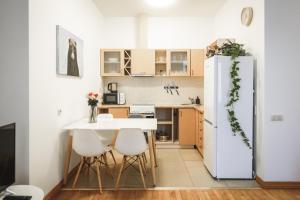 Il comprend une petite cuisine avec une table et un réfrigérateur blanc. dans l'établissement Bearsleys Archers Apartments, à Riga