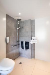 een badkamer met een douche en een toilet. bij Campanile Reims Sud - Bezannes in Reims