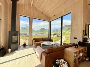 een woonkamer met een bank en een open haard bij Atlantic Panorama Lofoten in Leknes