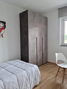 una camera con letto e sedia bianca di KD Apartment, accogliente, moderno e spazioso. a Castel di Sangro