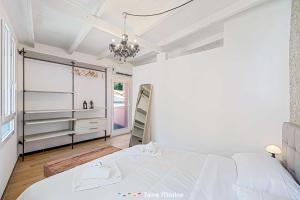 Habitación blanca con cama y lámpara de araña. en Incanto, TerreMarine, en Riomaggiore