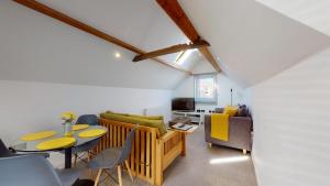 uma sala de estar com uma mesa e um sofá em Beautiful Coach House em Gloucester