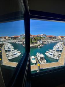 a view from a window of a harbor with boats at Las Rocas in Llanes