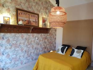 a bedroom with two beds and a chandelier at La Poussinière in Aiguèze