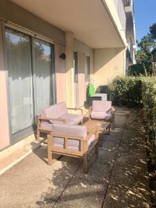 grupa krzeseł i stołów na patio w obiekcie Appartement authentique La Baule w mieście La Baule-Escoublac
