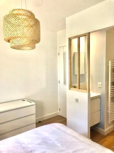 sypialnia z łóżkiem, lustrem i żyrandolem w obiekcie Appartement authentique La Baule w mieście La Baule-Escoublac