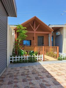 una casa de madera con una valla blanca delante de ella en كوخ ريفي تنومه, en Tanomah