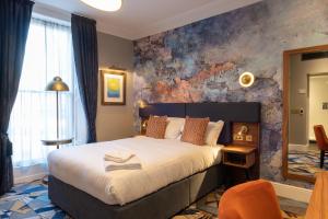 a bedroom with a large bed and a mirror at Keavan's Port Hotel , Dublin in Dublin