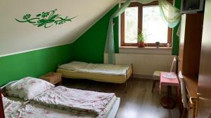 a room with two beds and a green wall at Penzión Gaboltov in Gaboltov