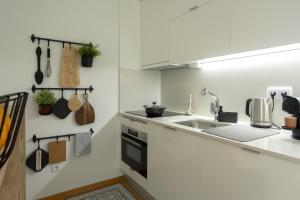 een witte keuken met een wastafel en een fornuis bij My Home is Yours in Porto