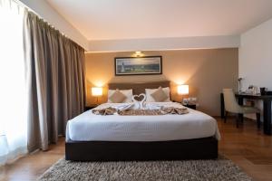 a bedroom with a large bed with a desk and a table at Signature Club Resort in Devanahalli-Bangalore