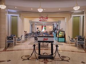 a lobby with a restaurant with tables and chairs at Grand Swiss-Belhotel Melaka in Melaka