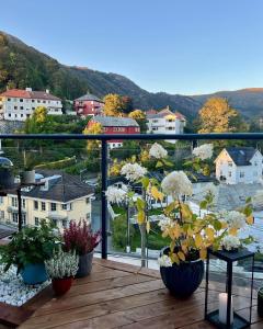 a balcony with potted plants and a view of a town at Top floor apartment with mountain view, terrace 22sqm, free parking in Bergen
