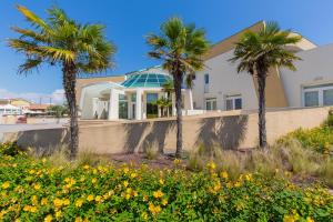 una casa con palmeras delante en Hotel Maregolf, en Caorle