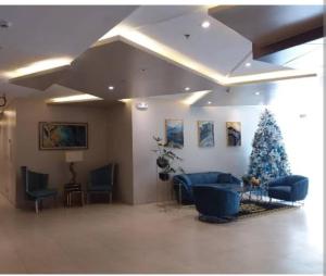 a living room with a christmas tree and blue furniture at Sunvida Tower Across SM City Cebu in Cebu City