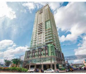 ein großes Hochhaus mit Leuten davor in der Unterkunft Sunvida Tower Across SM City Cebu in Cebu City