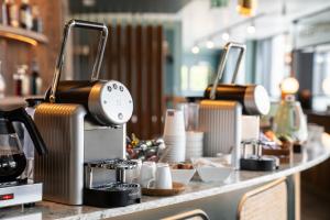 a counter with two coffee machines on it at Hotel D Bulle - La Gruyère in Bulle